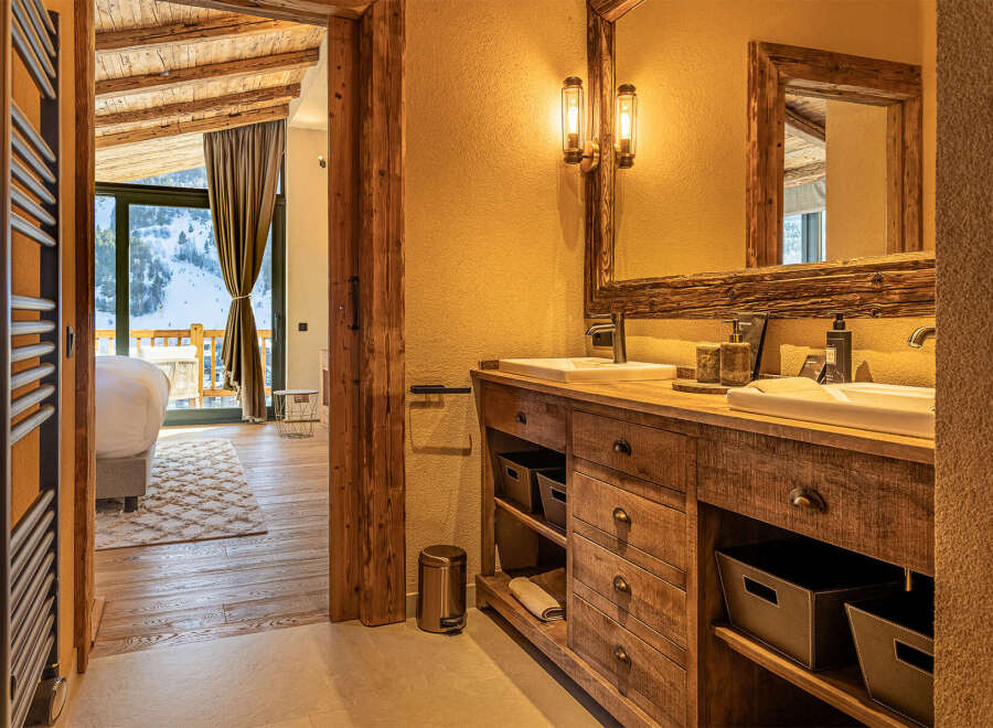 Experience luxury living in this stunning property, featuring a beautifully designed bathroom with rustic wooden accents and modern amenities.