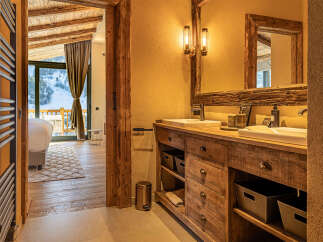 Experience luxury living in this stunning property, featuring a beautifully designed bathroom with rustic wooden accents and modern amenities.