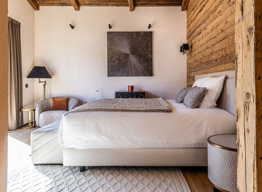 Experience luxury in this stunning bedroom featuring a cozy seating area and a plush bed.