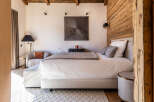 Experience luxury in this stunning bedroom featuring a cozy seating area and a plush bed.