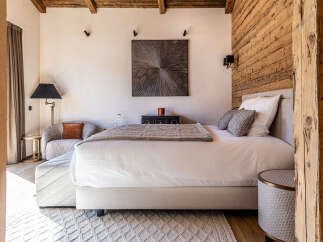 Experience luxury in this stunning bedroom featuring a cozy seating area and a plush bed.