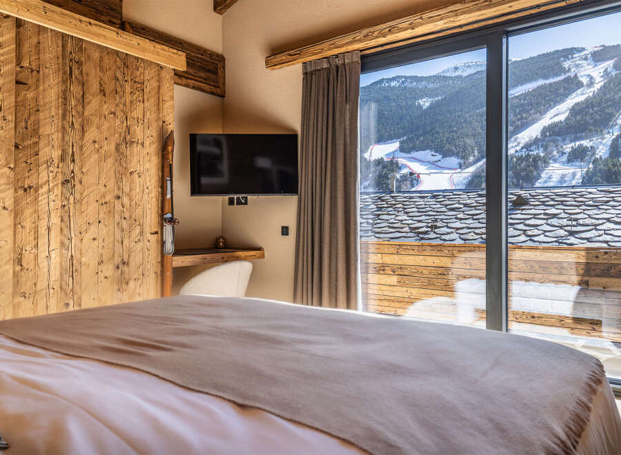 Experience the ultimate in luxury living with this stunning property, featuring a cozy bedroom with a view.
