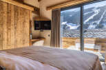 Experience the ultimate in luxury living with this stunning property, featuring a cozy bedroom with a view.