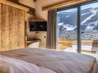 Experience the ultimate in luxury living with this stunning property, featuring a cozy bedroom with a view.