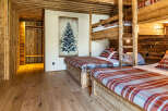 Experience rustic charm in this stunning bedroom featuring custom-built wooden bunk beds and a cozy, inviting atmosphere.