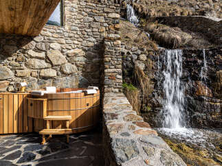 Experience ultimate relaxation in this stunning property featuring a luxurious wooden hot tub.