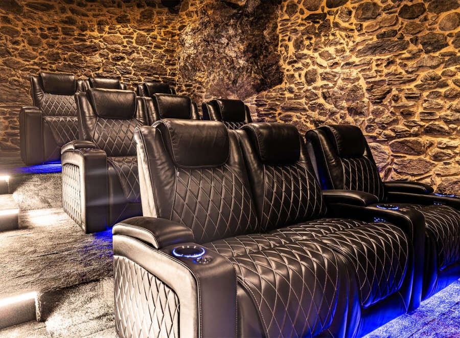 Step into luxury with this stunning home theater! Featuring plush, diamond-stitched leather seating and ambient blue lighting, this space is designed for ultimate comfort and entertainment.