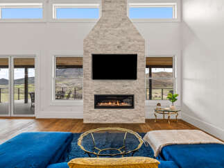 Experience luxury living in this stunning property featuring a modern fireplace and expansive windows.