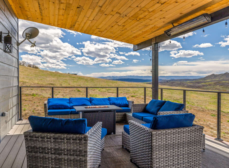Enjoy breathtaking views from this stunning outdoor living space! This property features a comfortable seating area with a fire pit, perfect for relaxing and entertaining.