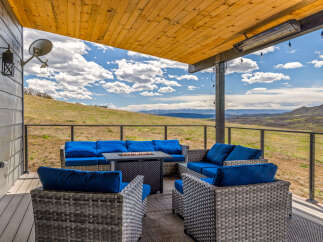 Enjoy breathtaking views from this stunning outdoor living space! This property features a comfortable seating area with a fire pit, perfect for relaxing and entertaining.