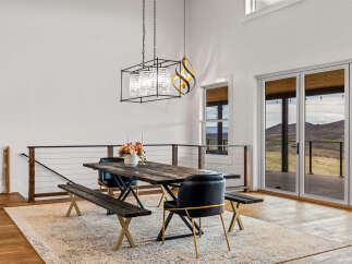 This stunning dining area features a rustic wooden table, perfect for hosting gatherings.