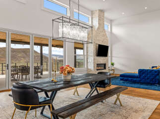 Experience luxury living in this stunning property featuring a modern dining area with a rustic wooden table and elegant chandelier.