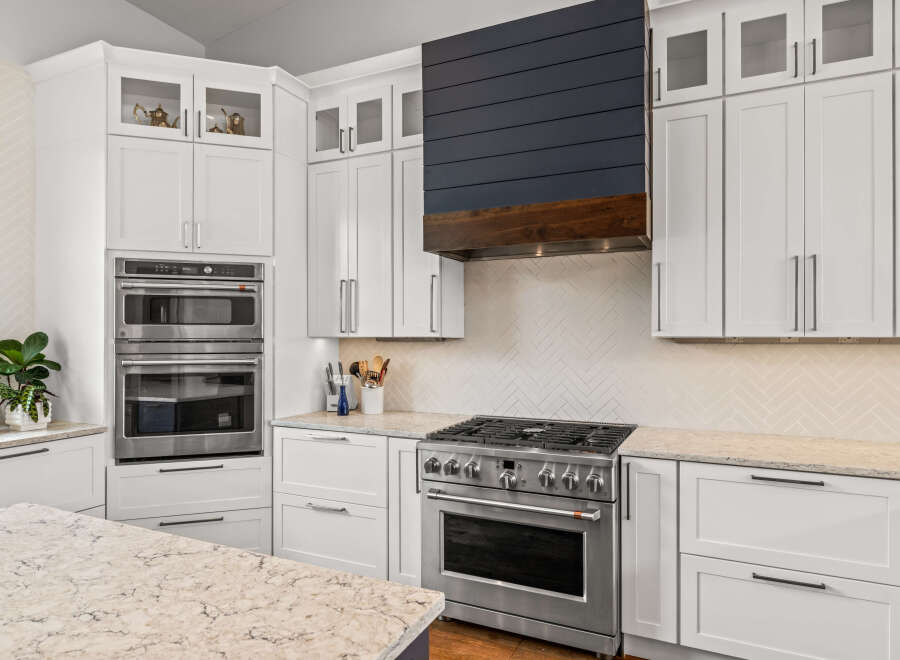 This stunning kitchen boasts modern design with sleek white cabinetry and stainless steel appliances.