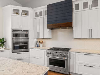 This stunning kitchen boasts modern design with sleek white cabinetry and stainless steel appliances.