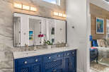 This stunning bathroom features a modern vanity with a striking blue finish, complemented by a sleek countertop and stylish faucets.