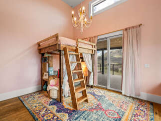 Step into this charming bedroom featuring a unique loft bed, perfect for a cozy and stylish space.
