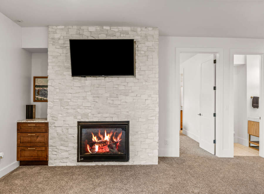 This stunning property features a cozy fireplace with a modern design, perfect for creating a warm and inviting atmosphere.