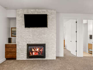 This stunning property features a cozy fireplace with a modern design, perfect for creating a warm and inviting atmosphere.