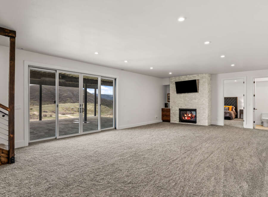 This stunning property boasts a spacious living area with a cozy fireplace and a mounted TV, perfect for relaxing evenings.