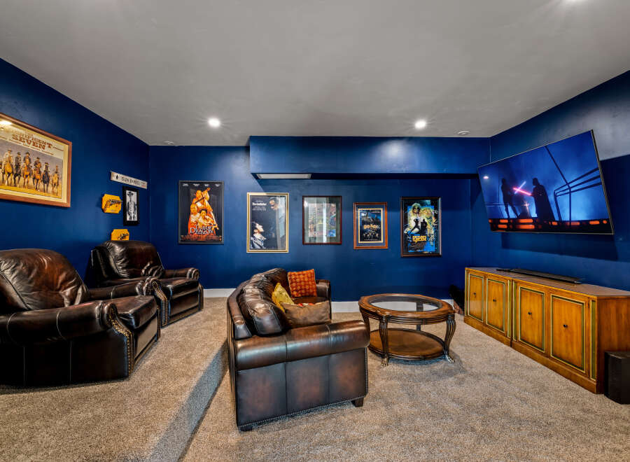 Step into luxury with this stunning home theater! Featuring plush leather seating, a large screen TV, and a stylish entertainment console, this space is perfect for movie nights and entertaining guests.