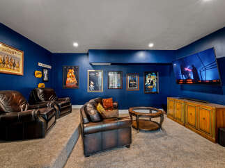 Step into luxury with this stunning home theater! Featuring plush leather seating, a large screen TV, and a stylish entertainment console, this space is perfect for movie nights and entertaining guests.
