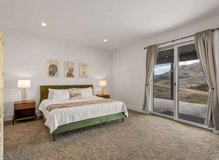 Step into luxury with this stunning bedroom featuring a plush green bed and elegant bedside lamps.