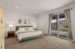 Step into luxury with this stunning bedroom featuring a plush green bed and elegant bedside lamps.