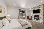 This luxurious bedroom boasts a cozy fireplace and a large flat-screen TV, perfect for relaxing evenings.