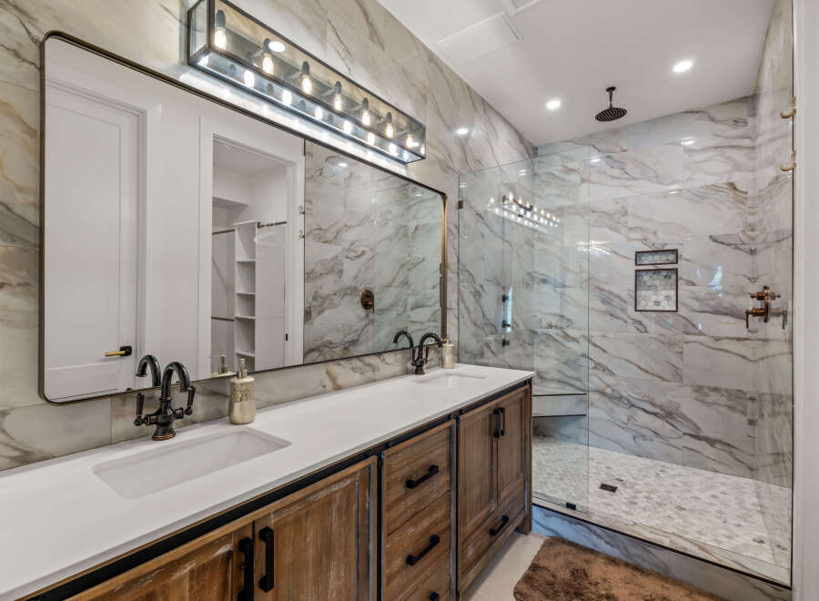This luxurious bathroom boasts a stunning marble-tiled shower and backsplash, creating a spa-like ambiance.
