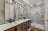 This luxurious bathroom boasts a stunning marble-tiled shower and backsplash, creating a spa-like ambiance.