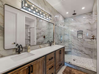 This luxurious bathroom boasts a stunning marble-tiled shower and backsplash, creating a spa-like ambiance.