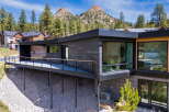 This stunning modern home offers a sleek design with a spacious deck, perfect for enjoying the beautiful mountain views.