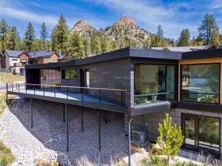 This stunning modern home offers a sleek design with a spacious deck, perfect for enjoying the beautiful mountain views.