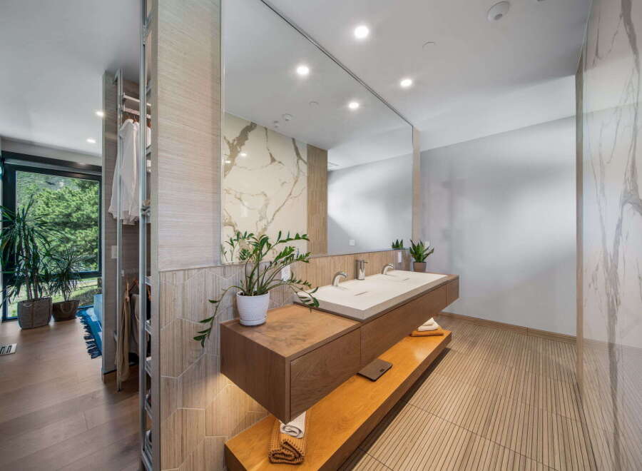Step into luxury with this stunning bathroom, featuring a sleek floating vanity and a large mirror that amplifies the space.