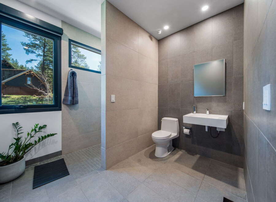 Step into a modern bathroom oasis! This stunning space features sleek tile work, a floating sink, and a contemporary toilet.