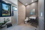 Step into a modern bathroom oasis! This stunning space features sleek tile work, a floating sink, and a contemporary toilet.