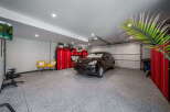 Step into luxury with this stunning garage, featuring a sleek epoxy floor and ample space for your vehicles and hobbies.