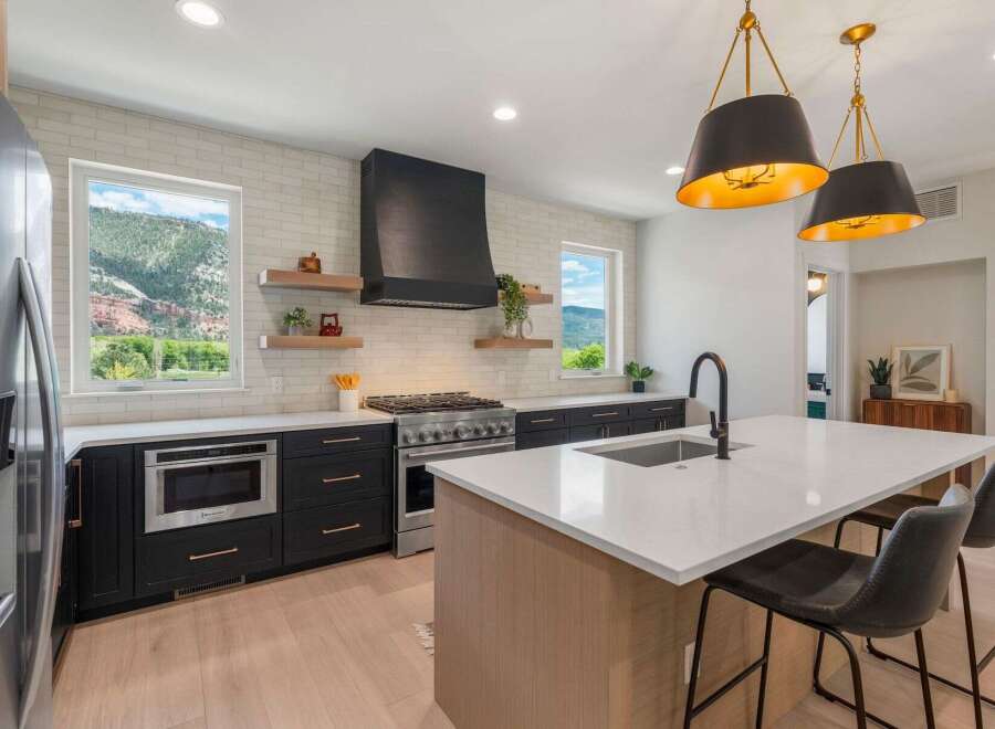 This stunning kitchen boasts modern design with sleek black cabinetry and a contrasting white countertop.