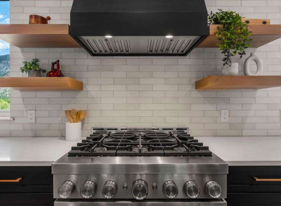 This stunning kitchen boasts a modern design with sleek stainless steel appliances and a stylish range hood.