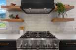 This stunning kitchen boasts a modern design with sleek stainless steel appliances and a stylish range hood.