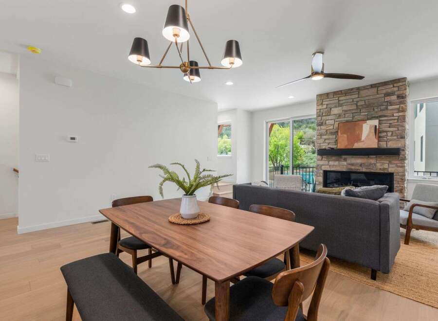 Step into modern elegance with this stunning property! Featuring a beautifully designed dining area with a stylish chandelier and a cozy living space with a stone fireplace, this home offers both comfort and sophistication.