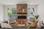 Experience the epitome of modern living in this stunning property, featuring a cozy living room with a stone fireplace.
