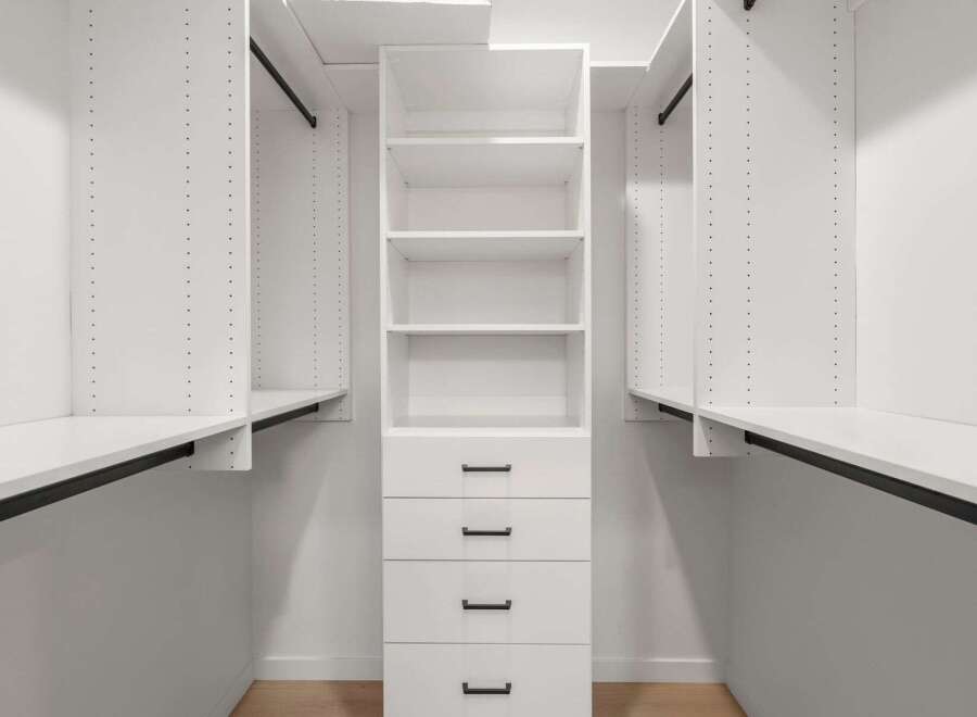 This custom closet offers ample storage with its built-in shelves and drawers, perfect for organizing your wardrobe.