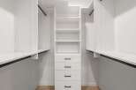 This custom closet offers ample storage with its built-in shelves and drawers, perfect for organizing your wardrobe.