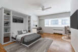 This stylish apartment features a modern bedroom with a comfortable bed and a built-in shelving unit.