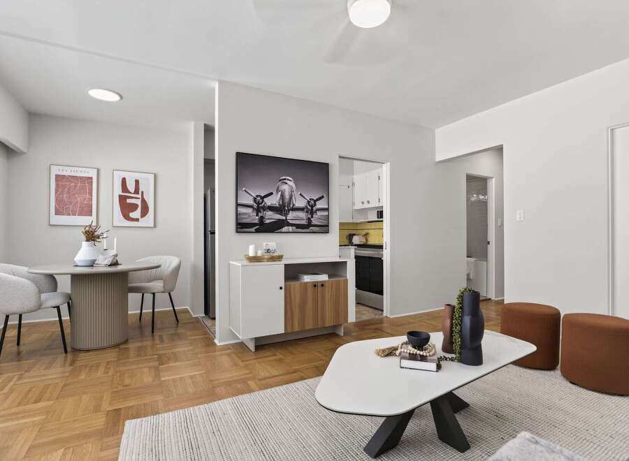 Discover modern living in this stylish apartment featuring a bright and airy living room with a unique coffee table and comfortable seating.