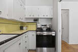Step into this charming kitchen, featuring classic white cabinetry and a sleek black countertop.