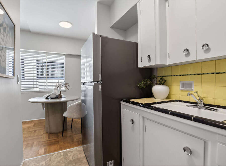 Discover this charming kitchen with a modern touch! Featuring sleek white cabinetry, a stylish sink area, and a refrigerator, this space is perfect for culinary adventures.