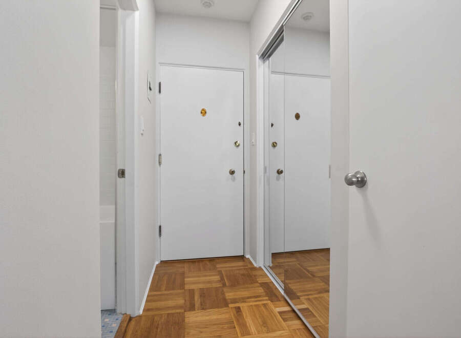 Step into this inviting entryway, featuring a stylish parquet floor and ample natural light.
