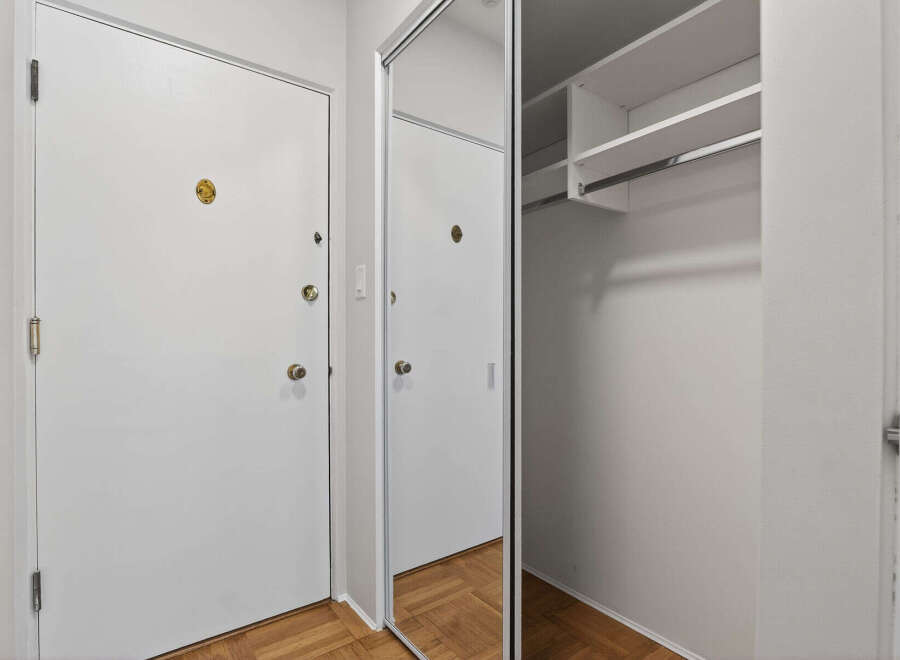 Step into this inviting entryway featuring a mirrored closet and ample storage space.
